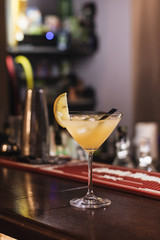 Delicious cocktail with ice cubes, lemon and straws in bar