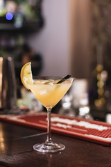 Delicious cocktail with ice cubes, lemon and straws in bar