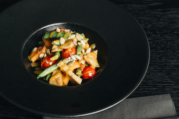 Fresh healthy dinner with seeds and vegetables on black plate
