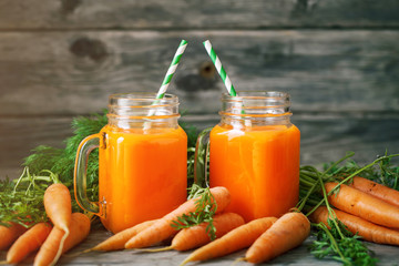 Fresh Carrot and carrot juice on Wooden Table in Garden. Vegetables Vitamins Keratin. Natural Organic Carrot lies on Wooden background.