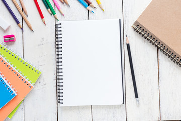 Top view, empty notebook and office supplies on the desk.