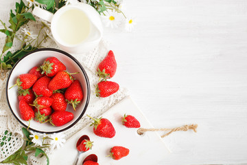 Ripe and tasty strawberry on a white wooden table.