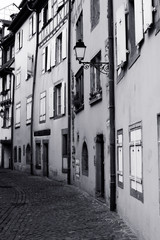 Narrow alley with cobbled street. Black and white image.