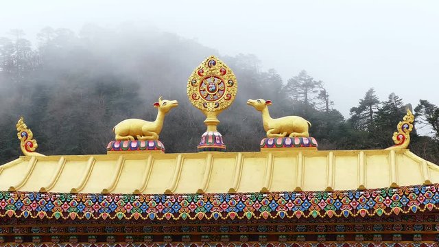 One of the most important symbols of Buddhism - Dharma Wheel on the background of the foggy forest. Tengboche temple, Solu Khumbu, Nepal.