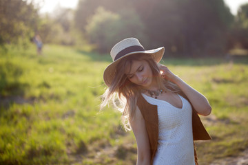 Cute charming girl in summer in the field. Young woman is happy and feels free outdoors