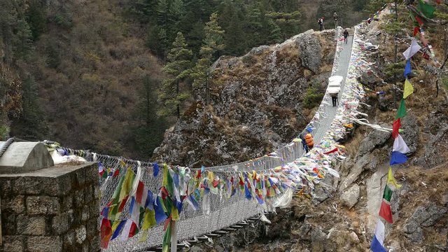 Largest suspension bridge in Solu Khumbu valley with colorful prayer flags, trekking area to the base camp of Everest peak (8848 m).
