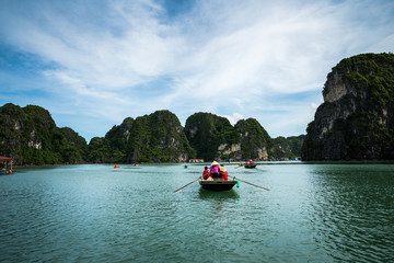 Fototapeta na wymiar Halong bay in Vietnam, UNESCO World Heritage Site, with tourist rowing boats