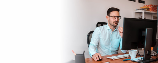 Focused man working in office on pc.