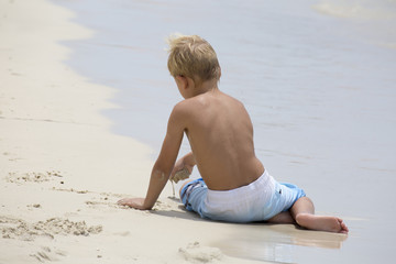 Fototapeta na wymiar Junge spielt am am Strand
