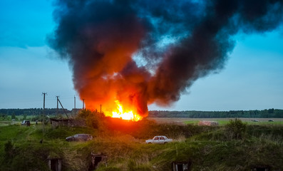 The fire in the village, people by cars escape from fire - the concept of disaster