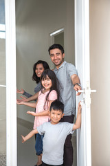 Fototapeta na wymiar happy family with kids open their house door 