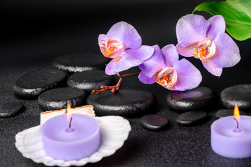 Obraz na płótnie Canvas spa concept of black zen stones, lilac orchid, candles