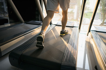 Fototapeta na wymiar Machine treadmill with people running closeup at fitness gym