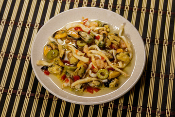 Seafood salad with shrimp, squid and mussels on bamboo mat