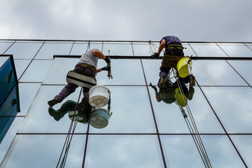 Industrial climbers are applying silicone on joints between windows