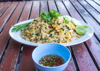 Stir fried cilantro with coriander and lemon, add white side dish, chili sauce, fish sauce Put on a brown wooden table.