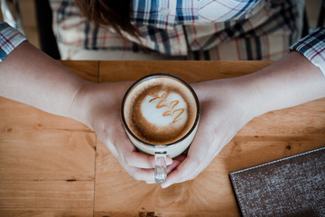 Female hands holding cups of coffee