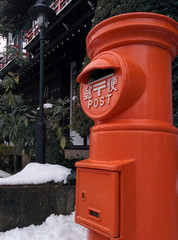 Fototapeta na wymiar japanese post box(retro-style) in the snow / 雪景色の中の昭和レトロ調の郵便ポスト - 年賀状シーズン