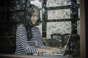 Woman freelancer is working and hands typing keyboard on a new project on laptop computer in cafe