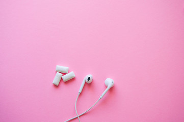 Headphones and menthol bubble gums on a pink background. Relaxation, life style concept. Copy space and top view.