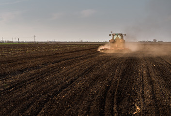 Fototapeta premium Tractor plowing fields -preparing land for sowing in autumn