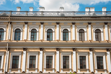 Fototapeta na wymiar Hotel facade yellow-orange building with window arches.