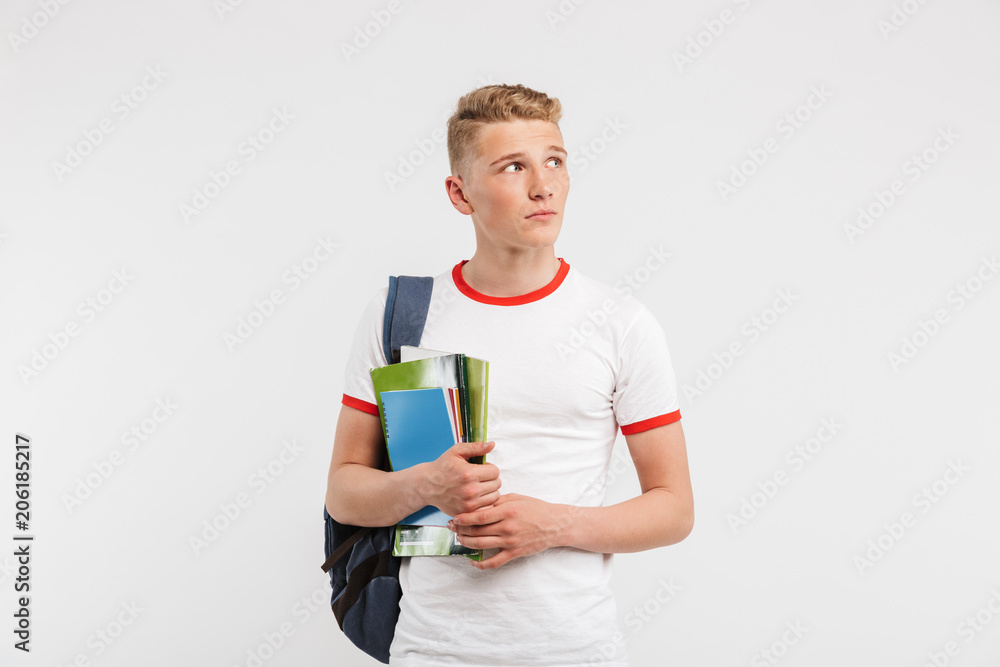 Wall mural image of young guy university or college student wearing backpack looking aside at copyspace while h