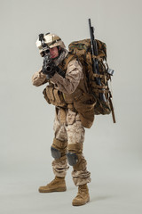 Soldier in camouflage holding rifle
