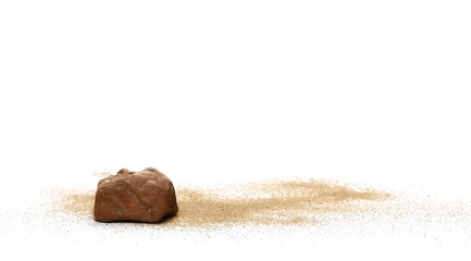 Red stone in sand pile isolated on white background