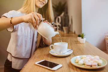 Beautiful young woman is drinking tea in a cafe, the morning.