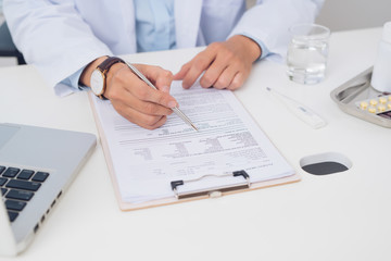 Fototapeta premium Male doctor working at desk in doctor's room