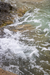 Water surface with limestone rocks, Comino coastline at the Blue Lagoon Bay, Comino island, Malta
