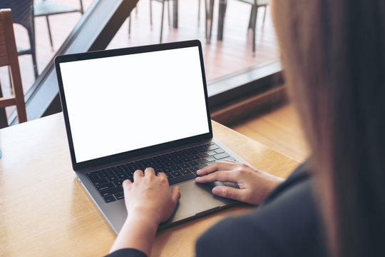 Mockup image of business woman using and typing on laptop with blank white screen in cafe