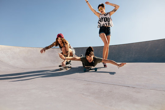 Group of women playing with skateboards - Powered by Adobe