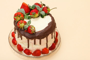 Homemade chocolate cake decorated with fresh strawberries on glass plate