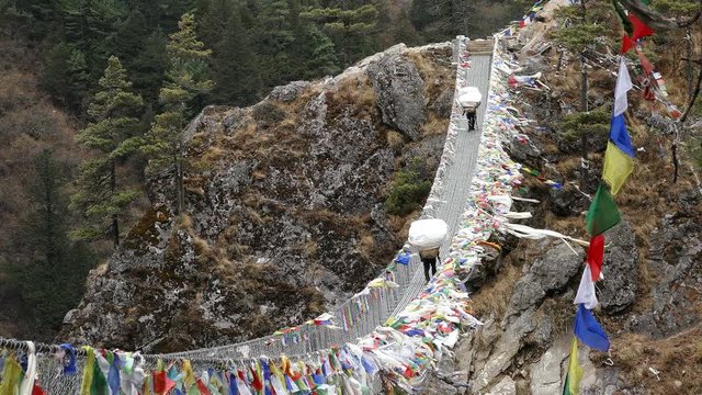 Largest suspension bridge in Solu Khumbu valley with colorful prayer flags, trekking area to the base camp of Everest peak (8848 m).