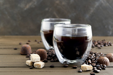 Coffee in double-walled glass on a wooden table.