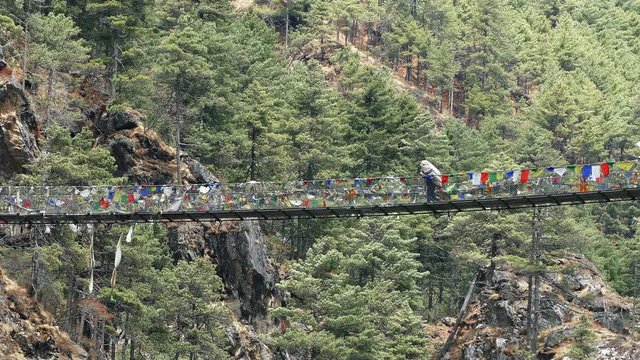 Largest suspension bridge in Solu Khumbu valley with colorful prayer flags, trekking area to the base camp of Everest peak (8848 m).