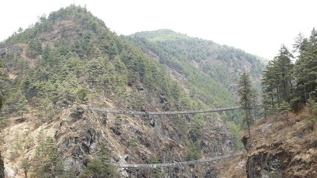 Largest suspension bridge in Solu Khumbu valley with colorful prayer flags, trekking area to the base camp of Everest peak (8848 m).