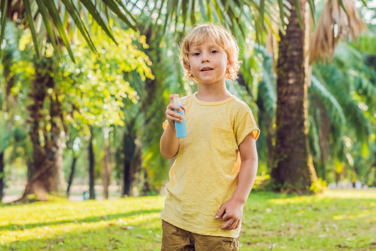 Boy spraying insect repellents on skin