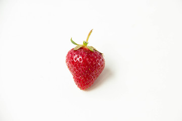 Fresh red strawberry with green leaves close-up on a white background