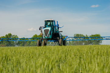 Fototapeta premium Agricultural sprayers, spray chemicals on young wheat.