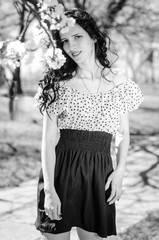 Beautiful Girl, brunette with red lips. Spring , shooting in the Park .Posing against the backdrop of flowering