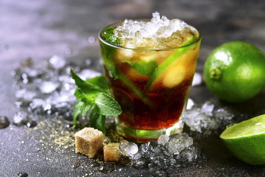 Cold refreshiing summer cocktail cuba libre or iced tea with lime.