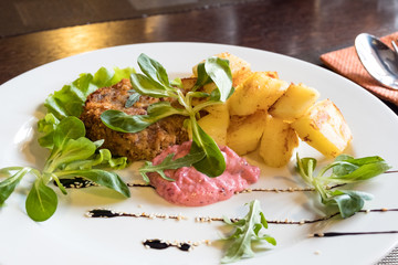 Meat cutlet with fried potatoes, herbs and sauce