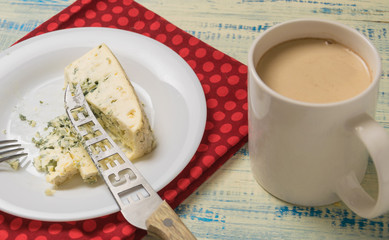 Blue cheese and a cup of coffee with milk.