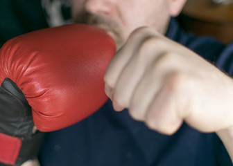 Boxer stand. The position of the hands with the box is to cover the chin. Unshaven chin and boxing gloves.
