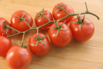 Natural-looking tomatoes on wooden background. Selective focus.