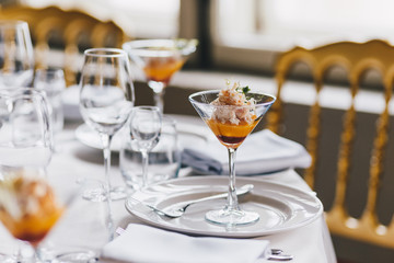 Elegant decorated dinner table with cutlery, glass of tasty cocktail, served in luxury restaurant. Banquet served table. Setting of restaurant. Exotic beverage. Horizontal view.