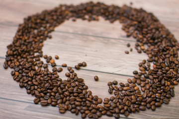 Coffee beans scattered on wood background top view with plase for text